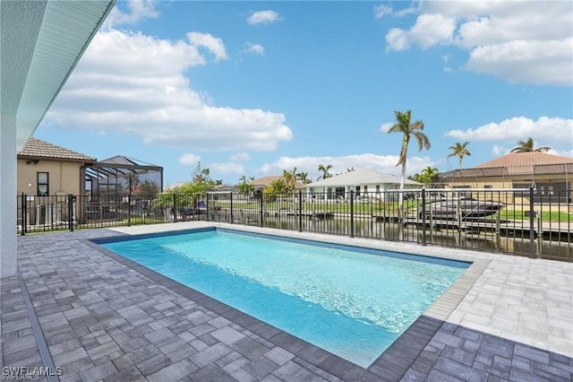 view of swimming pool featuring a fenced in pool, a water view, fence, and a patio