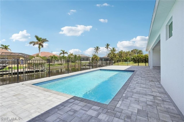 view of pool featuring a patio area, a water view, fence, and a fenced in pool