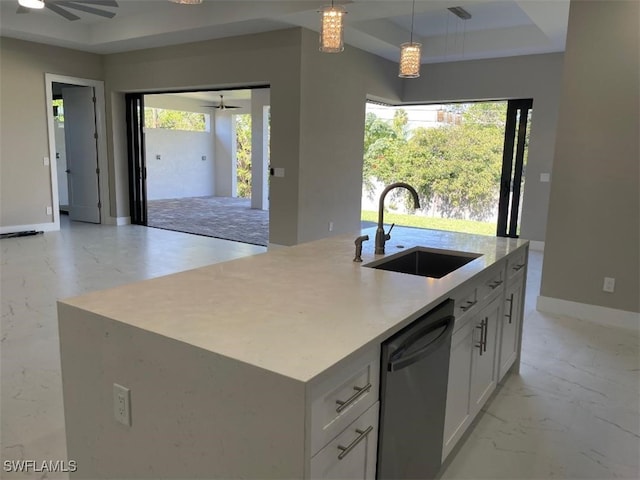 kitchen with dishwashing machine, marble finish floor, a tray ceiling, and a sink