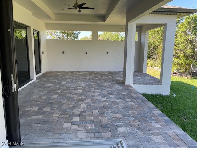 view of patio featuring a carport, decorative driveway, and ceiling fan