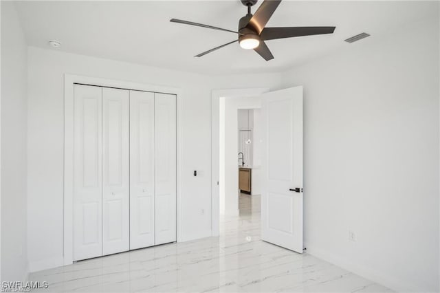 unfurnished bedroom featuring a closet, marble finish floor, visible vents, and baseboards