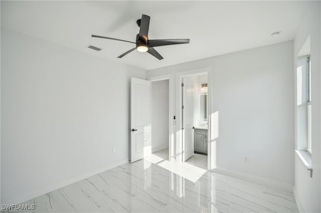 unfurnished bedroom with baseboards, visible vents, connected bathroom, a ceiling fan, and marble finish floor