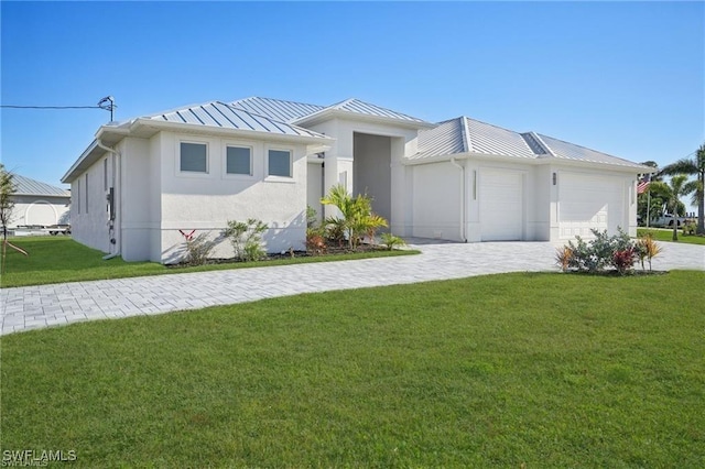 view of front of home with metal roof, a standing seam roof, decorative driveway, a front lawn, and stucco siding