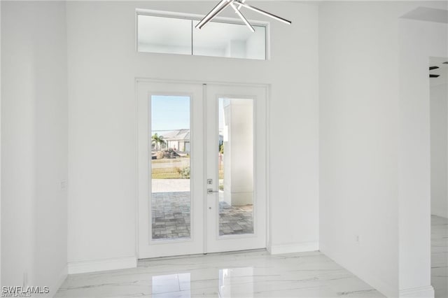 entryway featuring marble finish floor, baseboards, and french doors