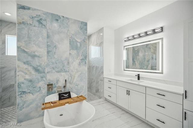 full bath with vanity, tile walls, marble finish floor, a soaking tub, and walk in shower