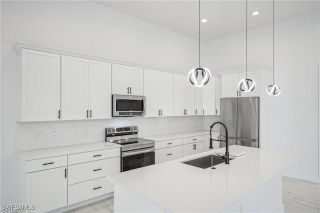 kitchen featuring marble finish floor, appliances with stainless steel finishes, a sink, and white cabinetry