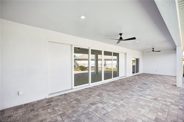 exterior space featuring brick patterned floor, a ceiling fan, and recessed lighting