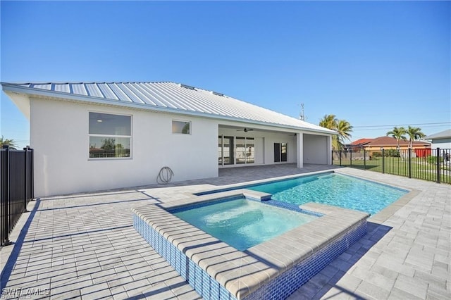 view of pool with ceiling fan, a patio, a fenced backyard, and a pool with connected hot tub