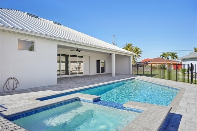 view of swimming pool with a pool with connected hot tub, fence, a ceiling fan, and a patio