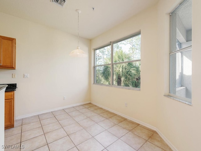 unfurnished dining area featuring visible vents, baseboards, and light tile patterned floors