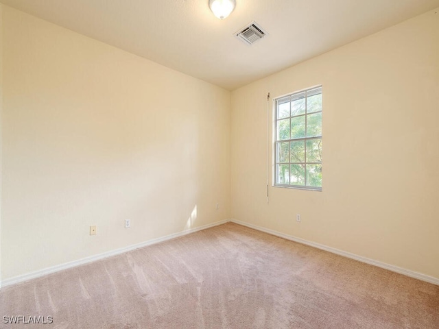 carpeted empty room featuring visible vents and baseboards