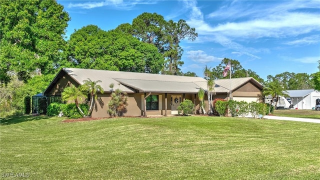 view of front of property with a front yard, concrete driveway, an attached garage, and stucco siding