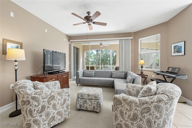 living room with light tile patterned floors, baseboards, and a ceiling fan