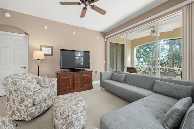 carpeted living area with a ceiling fan