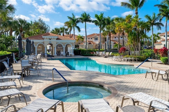 pool featuring a residential view, a community hot tub, and a patio