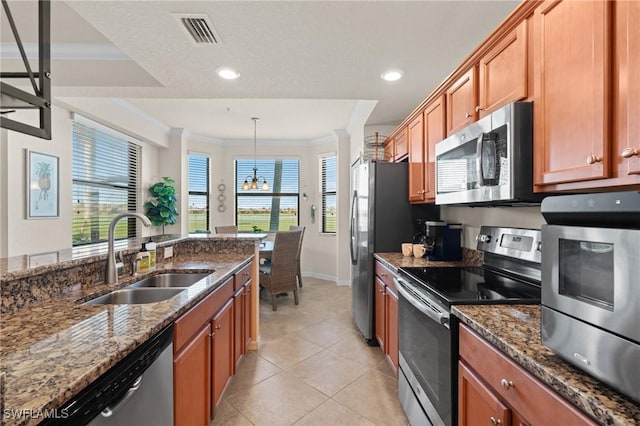 kitchen with a sink, visible vents, appliances with stainless steel finishes, dark stone counters, and pendant lighting