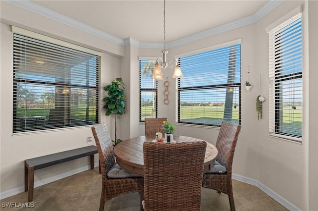 tiled dining room featuring an inviting chandelier, baseboards, and crown molding