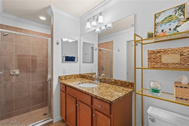 full bathroom featuring a stall shower, toilet, tile patterned floors, crown molding, and vanity