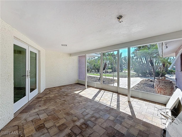 unfurnished sunroom with french doors