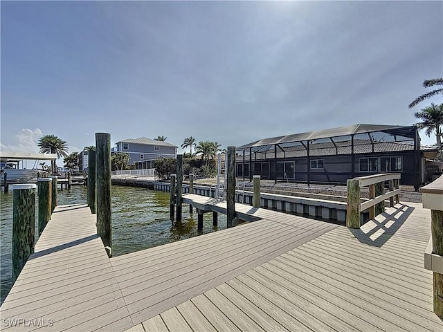 view of dock with a water view and glass enclosure