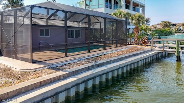 dock area with a water view, glass enclosure, and an outdoor pool