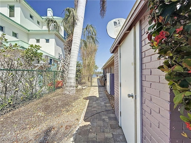 view of side of home with fence and a gate