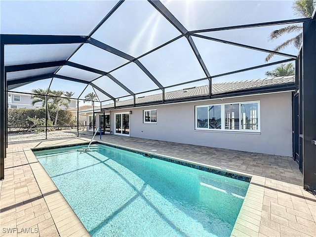 pool featuring glass enclosure and a patio