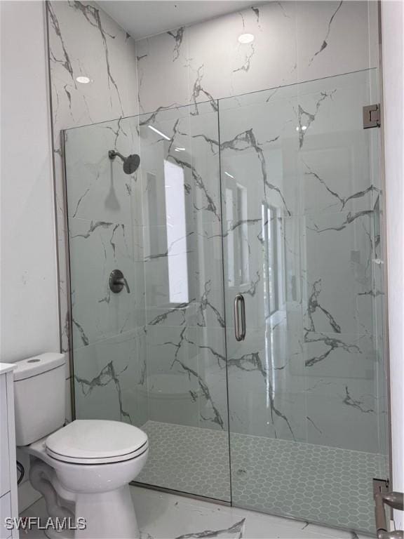 bathroom featuring marble finish floor, toilet, and a marble finish shower