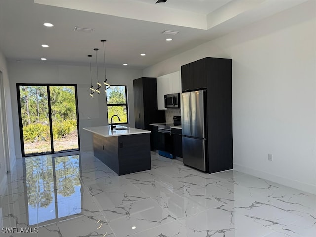 kitchen featuring modern cabinets, a sink, appliances with stainless steel finishes, light countertops, and dark cabinets