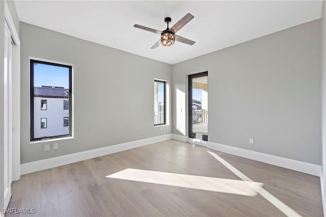 spare room featuring ceiling fan, a wealth of natural light, and light hardwood / wood-style flooring