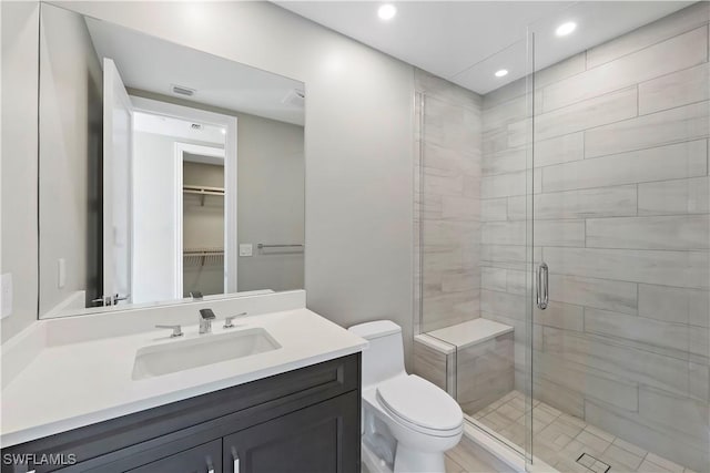 bathroom featuring vanity, an enclosed shower, and toilet