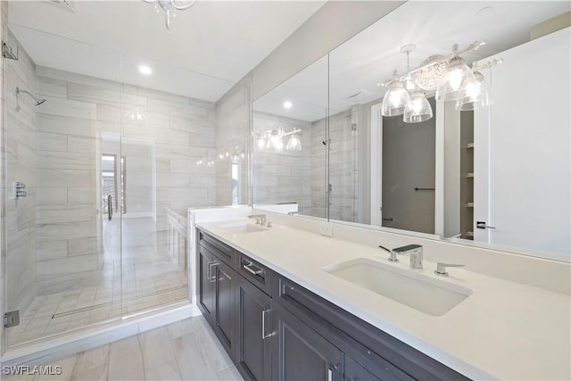 bathroom with a shower with shower door and vanity