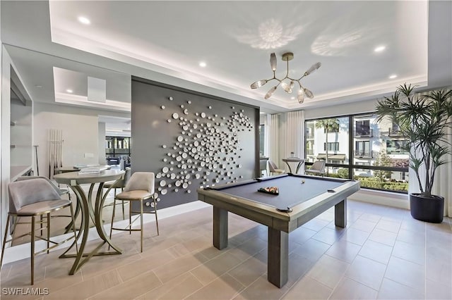 game room featuring a tray ceiling, a chandelier, pool table, and light tile patterned flooring