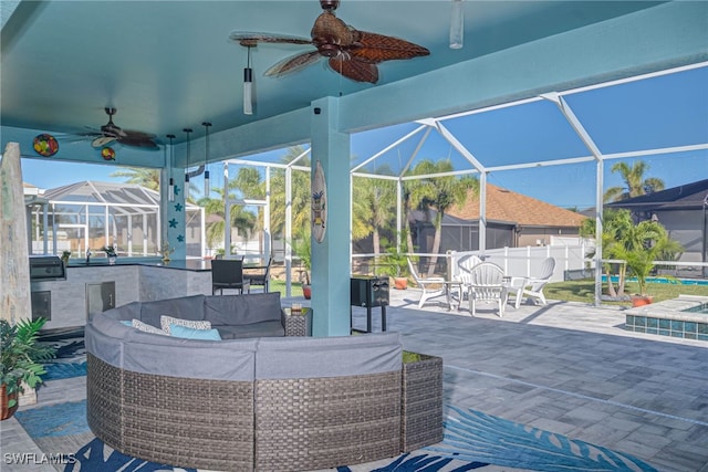 view of patio with an outdoor living space, an outdoor kitchen, glass enclosure, and ceiling fan