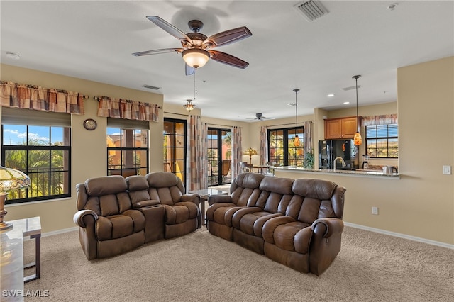 living area with light carpet, visible vents, and baseboards