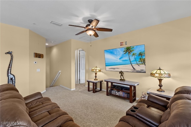 living area with visible vents, baseboards, arched walkways, a ceiling fan, and light colored carpet