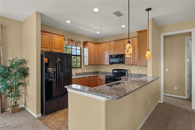 kitchen with a peninsula, hanging light fixtures, black appliances, brown cabinetry, and dark stone countertops