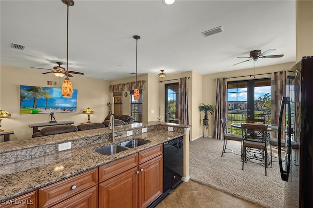 kitchen featuring brown cabinetry, visible vents, a sink, and black appliances