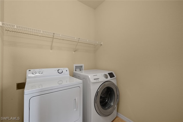 washroom with laundry area, baseboards, and washer and clothes dryer