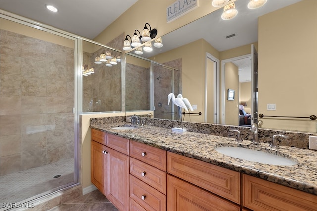 ensuite bathroom featuring double vanity, a stall shower, a sink, and visible vents