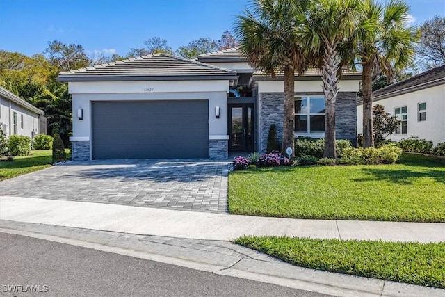 view of front of house with an attached garage, stone siding, decorative driveway, stucco siding, and a front lawn