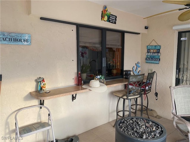 view of patio with a ceiling fan and exterior bar