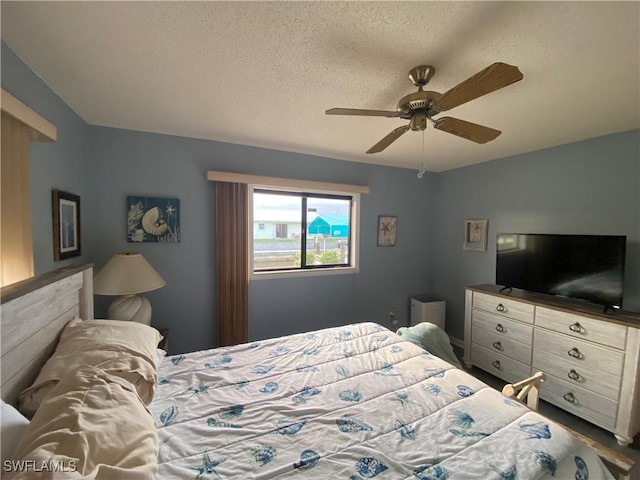 bedroom with a ceiling fan and a textured ceiling