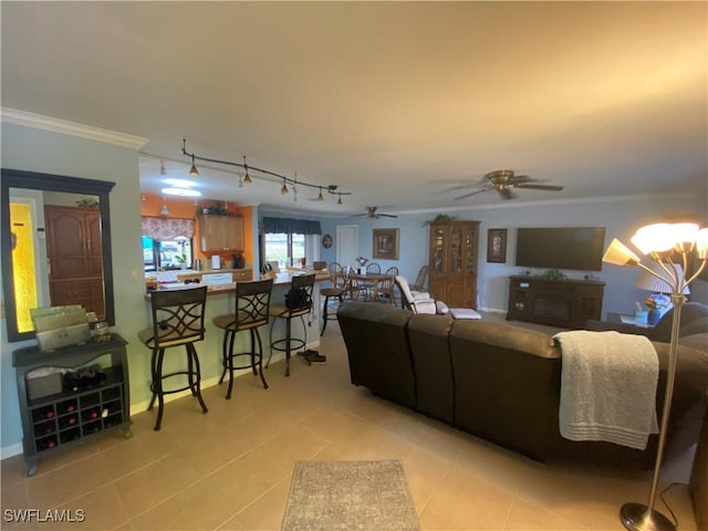living room with light tile patterned floors, ornamental molding, and a ceiling fan