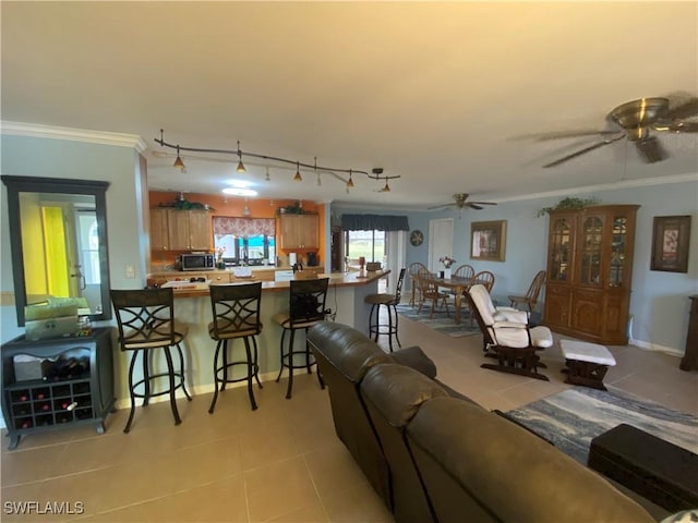 living room with rail lighting, a ceiling fan, crown molding, and light tile patterned flooring