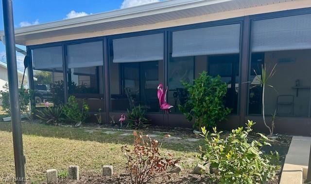 exterior space with a sunroom and a yard