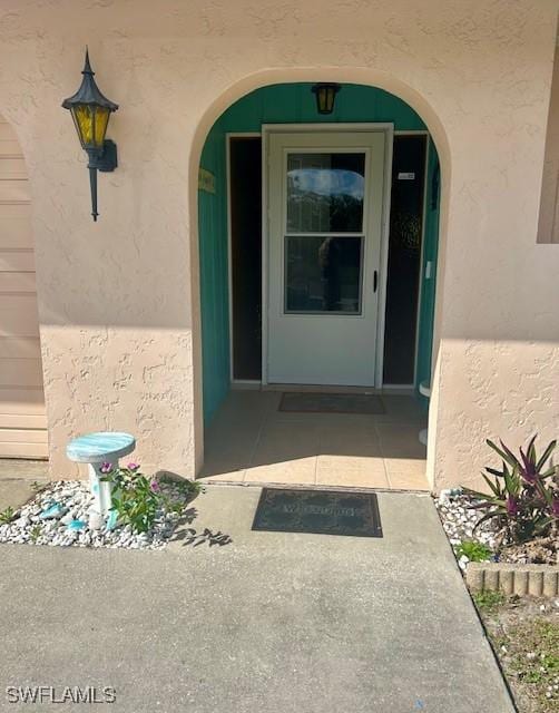 property entrance with stucco siding