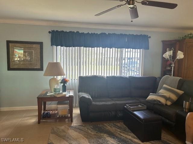 living room with tile patterned flooring, crown molding, baseboards, and ceiling fan