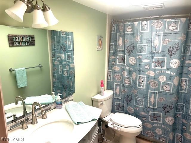 full bathroom with a shower with curtain, visible vents, vanity, and toilet