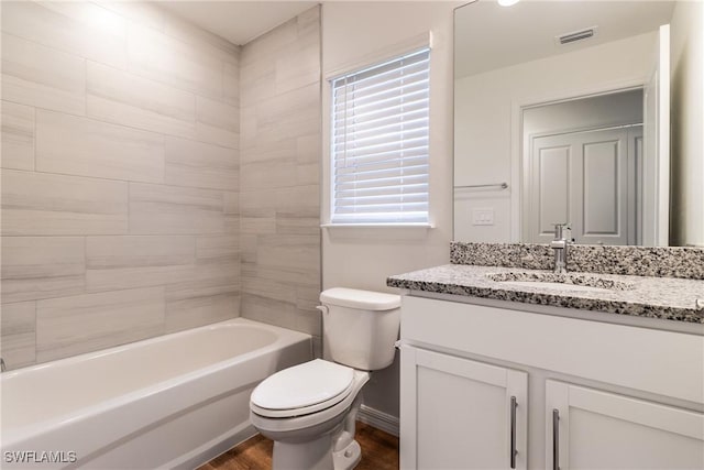 full bathroom featuring hardwood / wood-style flooring, toilet, vanity, and tiled shower / bath combo